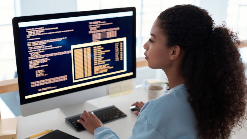 Woman testing computer software on a desktop screen, representing the testing phase in an ERP Migration Roadmap to Microsoft Dynamics 365 Business Central.