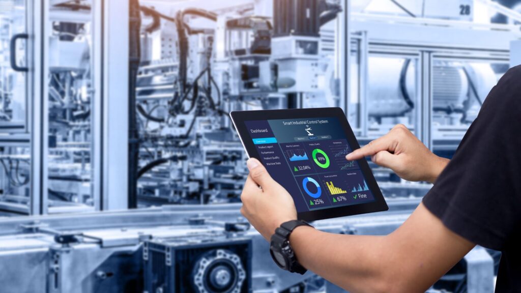 Person using a tablet to monitor real-time manufacturing dashboards in a factory, symbolizing ERP Strategy Success through data-driven decision-making and process optimization.