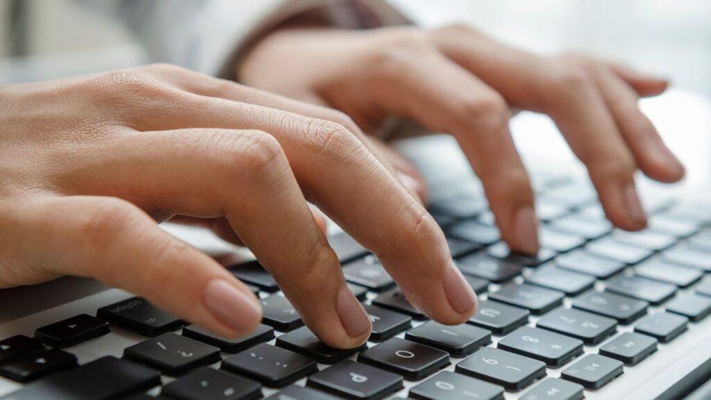 Close-up of hands typing on a laptop keyboard, representing ERP efficiency, digital workflows, and streamlined processes in business operations.