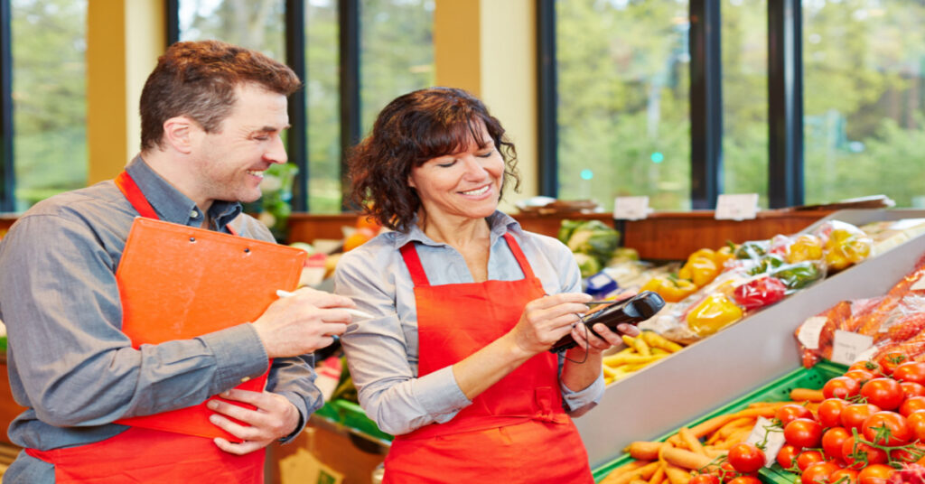 Staff in Grocery Store using mobile data for produce delivery