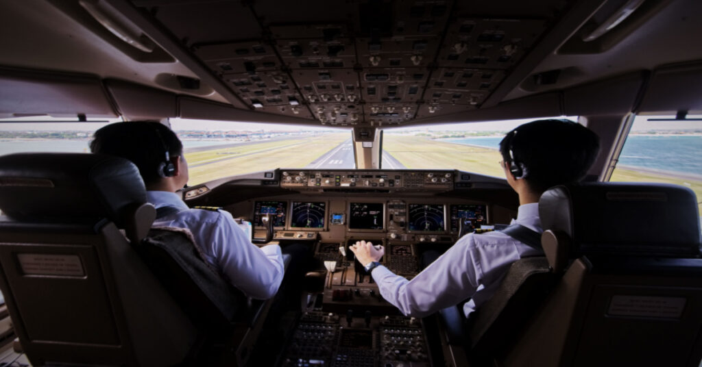 Two airliner pilots are flying an airplane toward the runway. Outside the cockpit, we see the landing runway and environment. We can see the pilots and all flight instruments and equipment inside the cockpit. – Microsoft Dynamics 365 Business Central Copilot