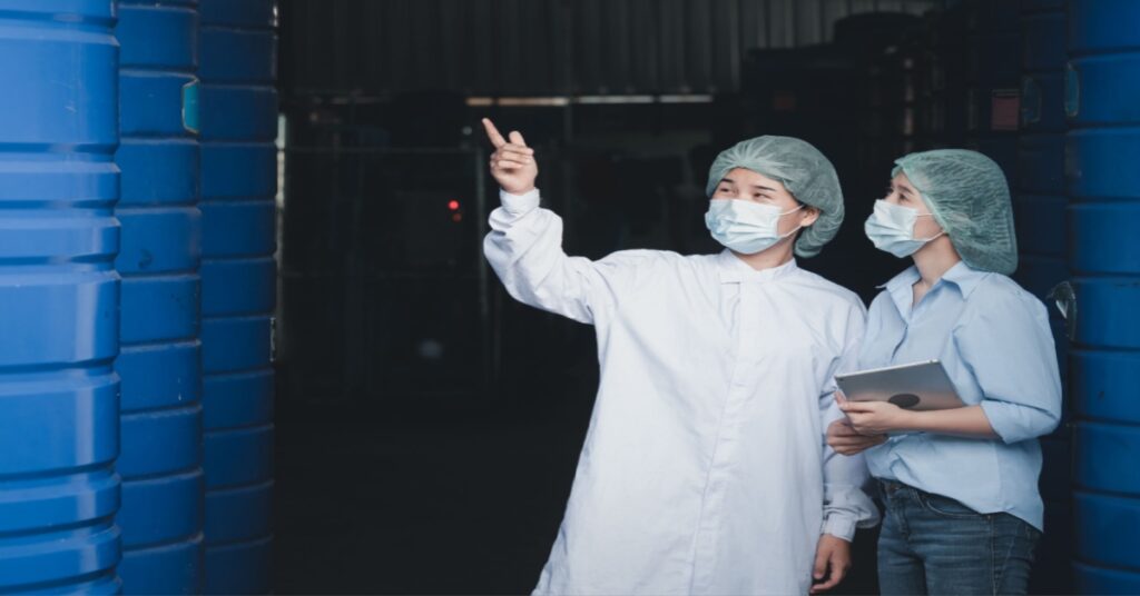 A female beverage factory worker announcing the number of raw materials for food production to the factory manager.