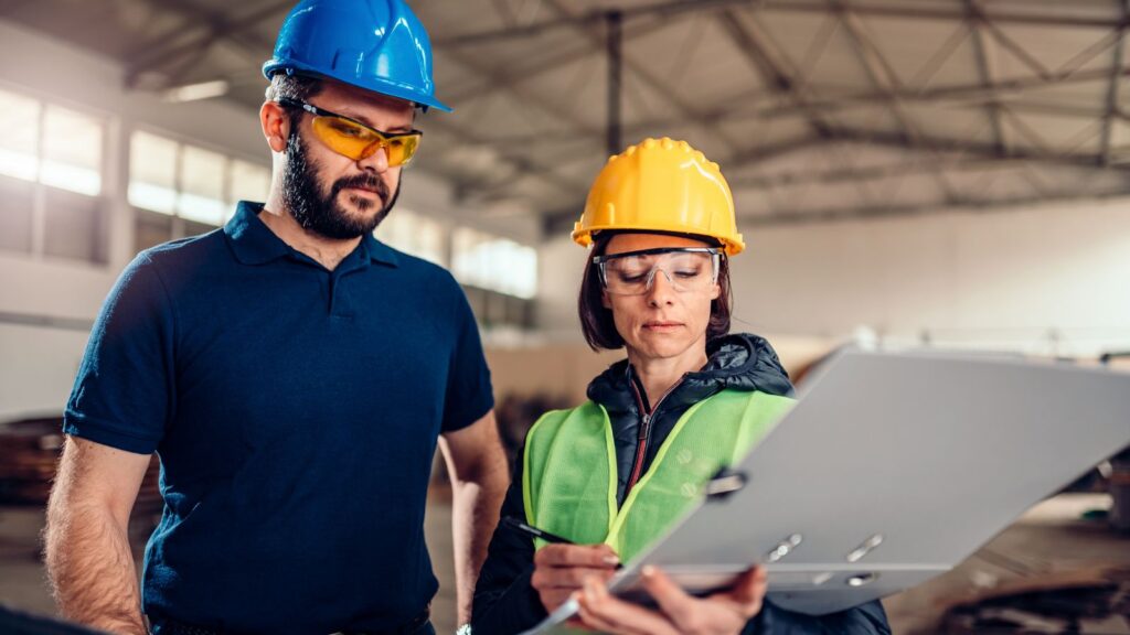 Factory supervisor checking production schedule at CNC machine