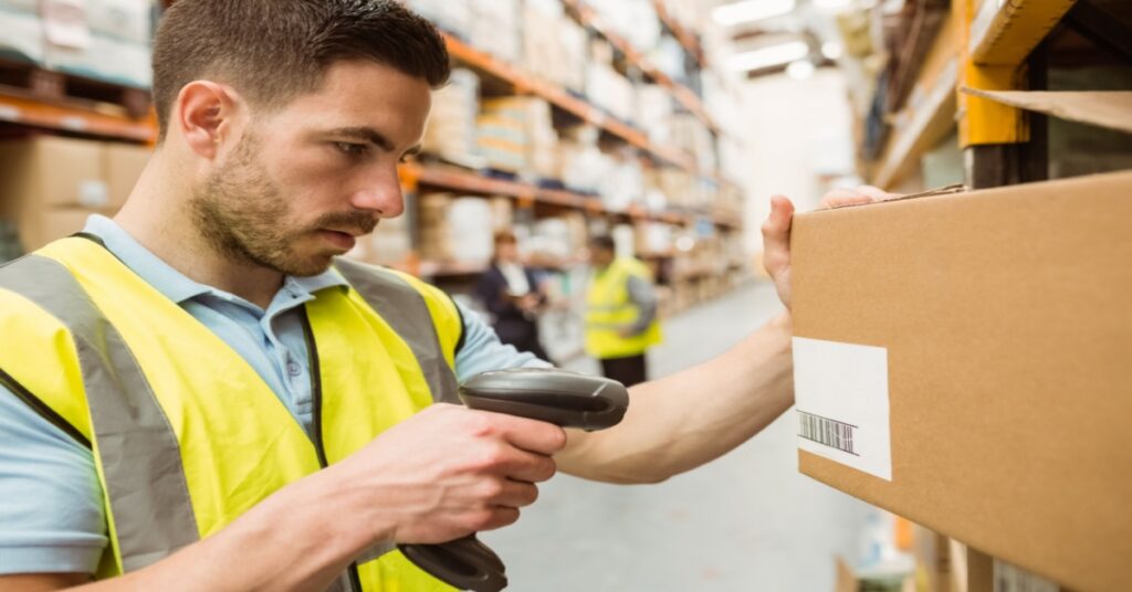 A male warehouse worker scanned barcodes on boxes – pallet barcoding