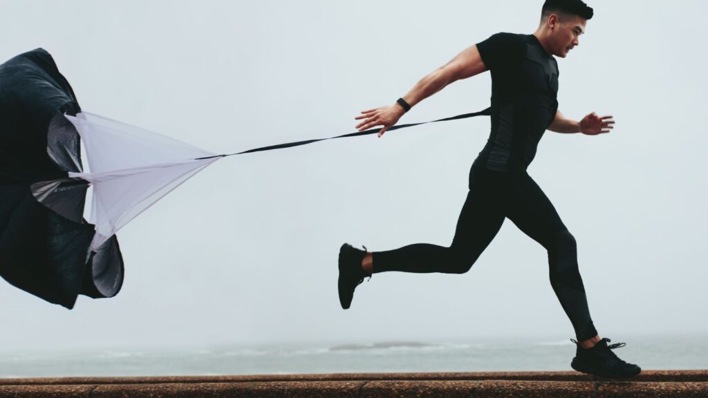 Mastering Change Management: Transform Your Dynamics 365 BC Journey 4 Athlete sprinting with resistance parachute for strength training—symbolizing overcoming obstacles during ERP implementation or change management challenges.