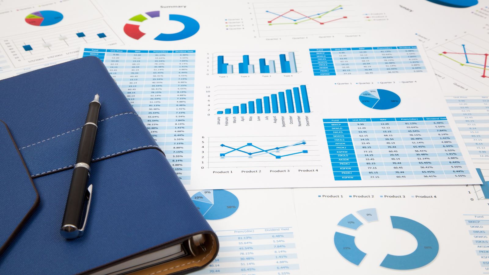 Charts and graphs displaying business performance data next to a notebook and pen, illustrating the benefits of Business Central SaaS such as enhanced reporting, seamless collaboration, and continuous security updates.