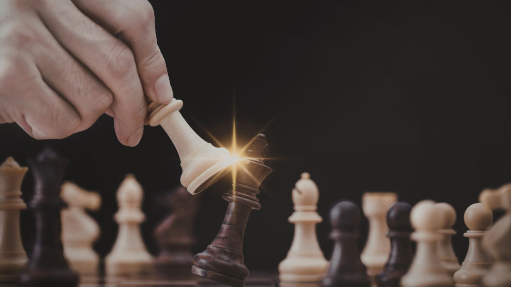 Close-up of a hand moving a white chess king to capture a black king on a chessboard, symbolizing strategic leadership, competitive advantage, decisive business strategy, and calculated decision-making in corporate or ERP transformation initiatives.